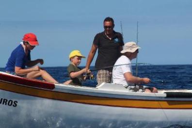 Family fishing on a boat with a guide